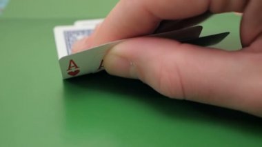 Profesyonel bir poker oyuncusunun elinde iki as. Kumar kavramı. Profesyonel poker oyuncusu oynamadan önce kartları kontrol eder. Poker oyuncusu bahsi arttırmadan önce kartlarını kontrol eder.