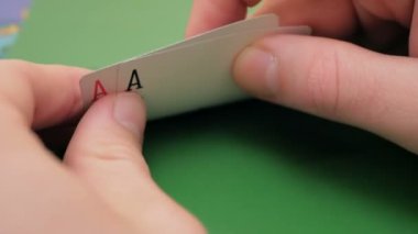 Profesyonel bir poker oyuncusunun elinde iki as. Poker oyuncusu bahsi artırmadan önce kartlarını kontrol eder. Profesyonel poker oyuncusunun iki ası vardır. Kumar anlayışı. Profesyonel.