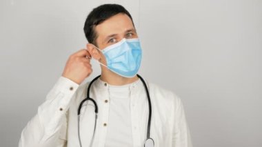 Genç, yakışıklı bir doktor koruyucu maskesini çıkarır ve ağır ağır iç çeker..