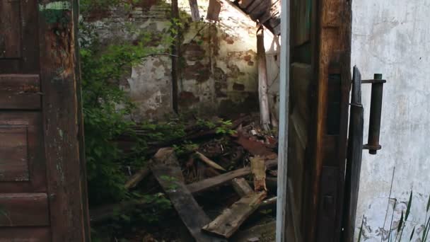 La vecchia porta di una casa abbandonata e rovinata. Una vecchia porta in un edificio abbandonato si chiude da sola. — Video Stock