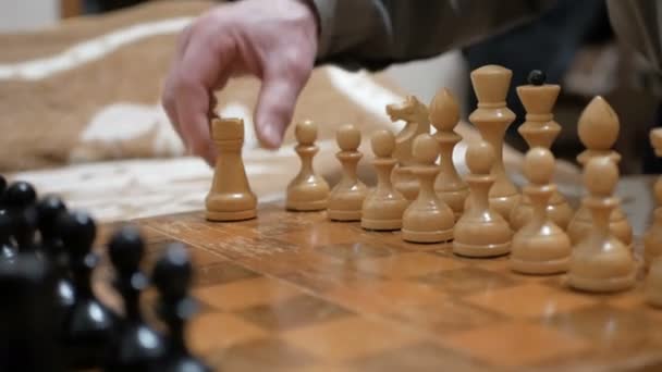 Primer plano de la mano de un hombre y una joven jugando al ajedrez.Un anciano y una joven están arreglando piezas de ajedrez en un tablero de ajedrez, preparándose para jugar. — Vídeo de stock