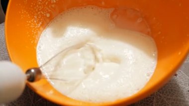 Şef çırpıcıyla organik süt kreması çırpıyor..