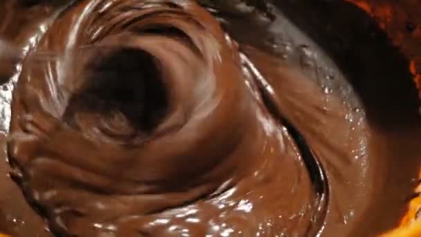 El chef mezcla el chocolate con una licuadora, preparando los ingredientes para el pastel. El chef mezcla la crema de chocolate para el pastel con una batidora. — Vídeo de stock