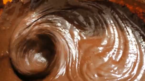 The chef mixes the chocolate cream for the cake with a mixer. Close-up of a chef stirring a chocolate dough with a blender to make a brownie. — Stock Video