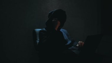 Siyah kapüşonlu bir hacker kurbanını telefonla arıyor ve veritabanı şifrelerini kırmakla tehdit ediyor. Siyah kar maskeli bir internet korsanı sandalyeye oturur ve laptoptan veri çalar.