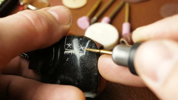Un gravor profesionist creează o bucată de bijuterii făcând caneluri cu un tăietor special . — Videoclip de stoc