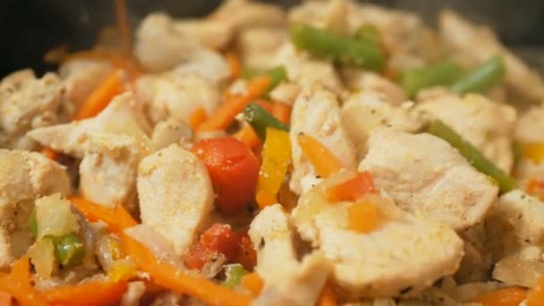 Šéfkuchař míchá kuře se zeleninou na pánvi. Profesionální kuchař připravuje kuře se zeleninou ve wok. Šťavnaté kuřecí filet se smaží ve wok s čerstvou zeleninou. — Stock video