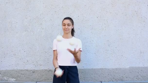 Professionelle Zirkusartisten jonglieren auf der Straße mit weißen Bällen. Ein professioneller Jongleur jongliert mit weißen Bällen. — Stockvideo