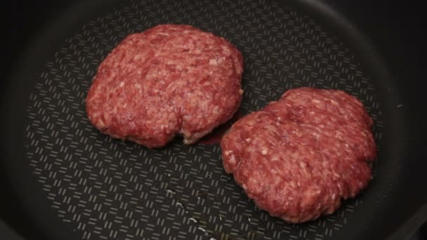 シェフはグリルに牛肉のパテを置きます。ジューシーな牛カツ,鍋で揚げ.グリルでハンバーガーのための牛肉カツのクローズアップ. — ストック動画