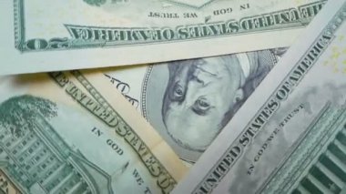 Bir masanın üzerinde dönen 100 dolarlık banknotun yakın plan görüntüsü. Yakın plan banknotlar masanın üzerinde dönüyor. Benjamin Franklins 'in yüzü 100 dolarlık banknotun üzerinde..