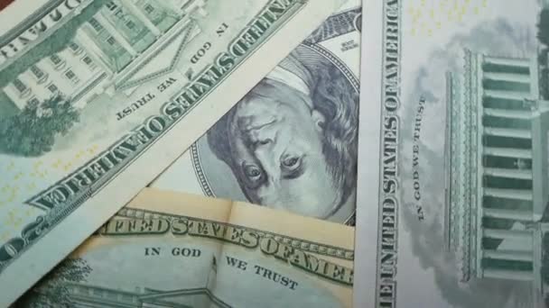 Close-up of dollar bills rotate on the table.Close-up of Benjamin Franklins face on one hundred dollar bill. — 비디오