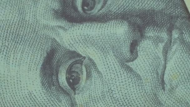 Close-up of dollar bills rotate on the table.Close-up shot of a hundred dollar bill that rotates on a table.Close-up of Benjamin Franklins face on one hundred dollar bill. — Wideo stockowe