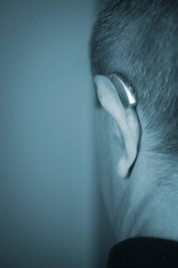 Modern dijital işitme cihazı orta yaşlı 50 'li yaşlarda bir adamın kulağında