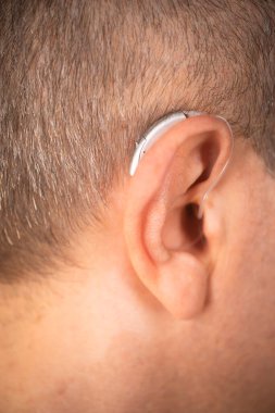 Modern dijital işitme cihazı orta yaşlı 50 'li yaşlarda bir adamın kulağında