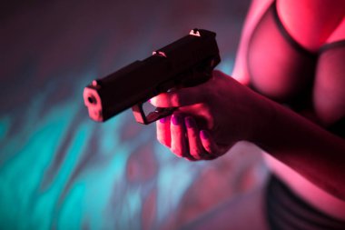 Seksi, iri göğüslü, otomatik tabancalı, erotik iç çamaşırlı kadın..
