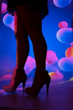 Uzun bacaklı seksi kadın erotik yüksek topuklu ayakkabı ve mini etek giyiyor..