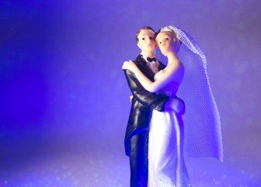 Düğün çifti pasta üstte plastik figürler smokin gece elbisesi, beyaz gelinlik peçesi.