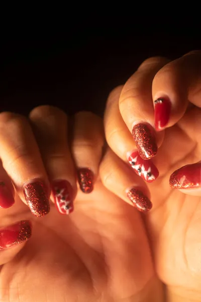 Lady with painted red nail varnish nails and manicure hands.