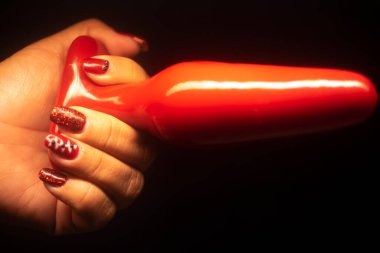 Sexy lady holding erotic adult love toy buttplug dildo.