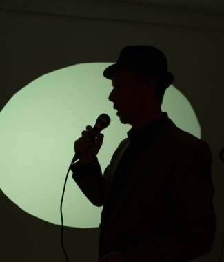 Stüdyo mikrofonunda şarkı söyleyen erkek şarkıcı albüm kapağı tasarımında.