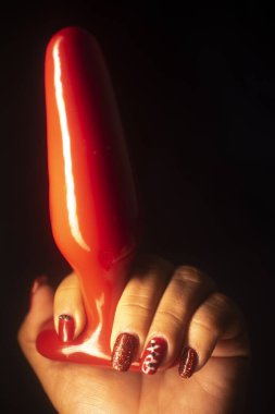 Sexy lady holding erotic adult love toy buttplug dildo.