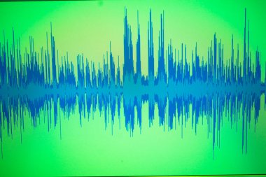 Stüdyo ses sanatçısı diyalog ses dalgalarını bilgisayar ekranında kaydediyor.