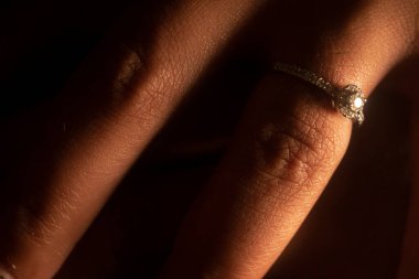 Nişan yüzüğü, evlenmek üzere olan genç bir çiftin parmağında..