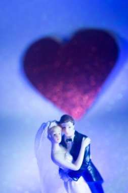 Düğün çifti pasta üstte plastik figürler smokin gece elbisesi, beyaz gelinlik peçesi.