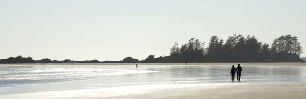 Paar geht am Strand spazieren lizenzfreie Stockbilder