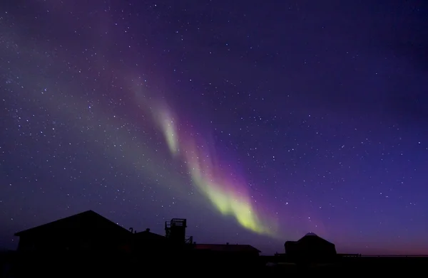 Aurora borealis over een gebouw silhouet — Stockfoto