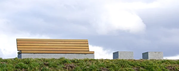 Moderne Bank op een met gras begroeide knoll 1 — Stockfoto