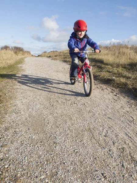 Kleine jongen fietsen in de duinen — Stockfoto