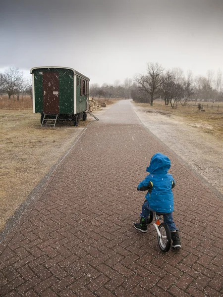 Pojke på cykel i en hagelstorm — Stockfoto