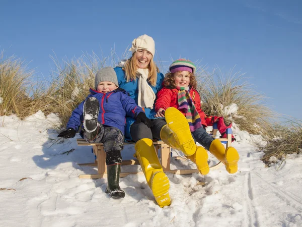 母亲和小儿童坐在雪橇上 — 图库照片