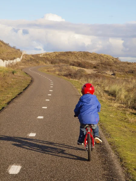 Piccolo ragazzo in bicicletta attraverso le dune — Foto Stock