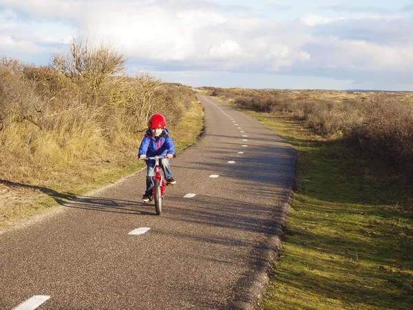 Petit garçon à vélo à travers les dunes — Photo