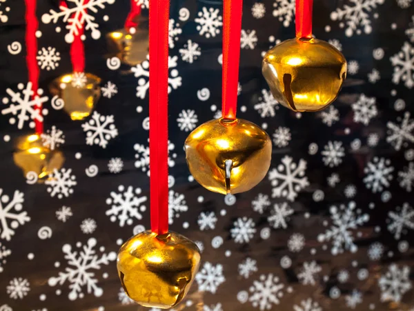 Three sleigh bells hanging on red ribbons — Stock Photo, Image