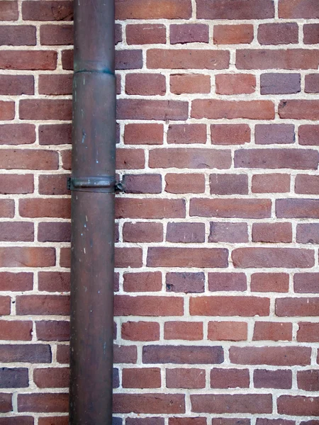 Drainpipe against brick wall — Stock Photo, Image