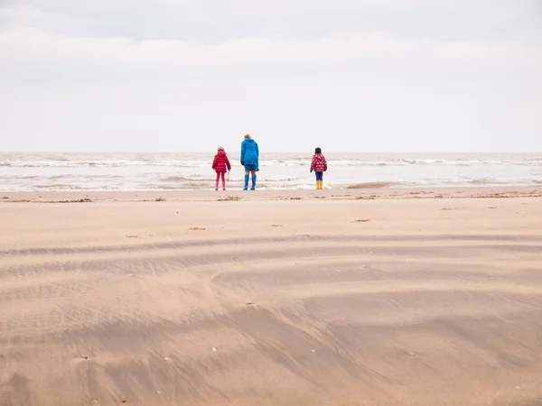 Mulher e duas crianças pequenas na praia de inverno — Fotografia de Stock