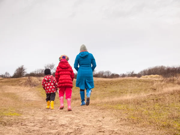 Mulher e duas crianças pequenas andando em dunas no inverno — Fotografia de Stock