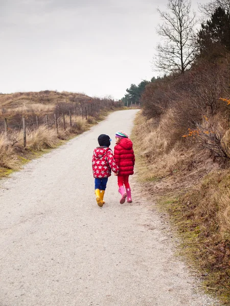 Liten pojke och flicka gå hand i hand — Stockfoto