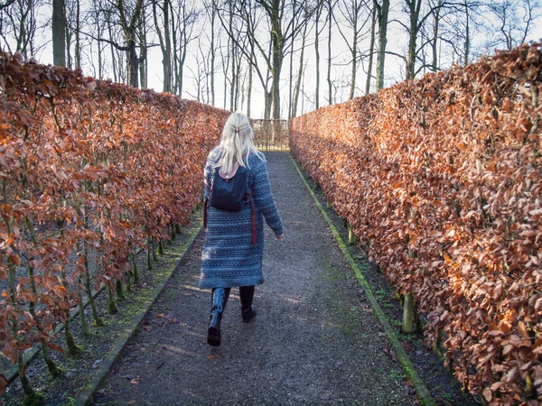 Kvinnan promenader genom en labyrint — Stockfoto