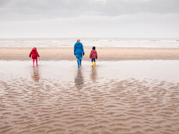 Mujer y dos niños pequeños en la playa de invierno Imagen De Stock