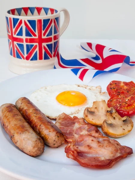 Engels ontbijt met kop van thee en Britse vlag achter — Stockfoto