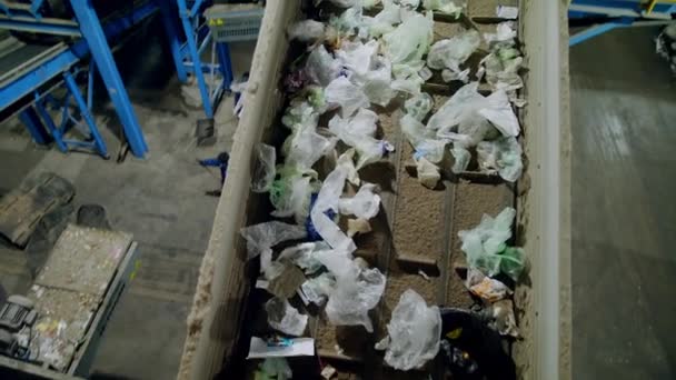 Plastik torbalar atık geri dönüşüm tesisinde konveyör boyunca hareket ediyor. — Stok video