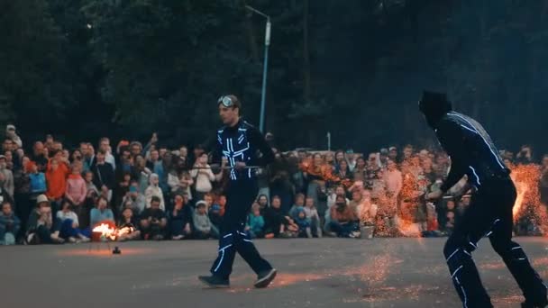 Akteure der Feuershow zeigen einen Trick mit heißen Kohlen, Funken fliegen im Wind. — Stockvideo