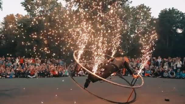 Schauspieler der Feuershow führt Trick mit Rad und Wunderkerzen auf, Wunderkerzen funkeln. — Stockvideo