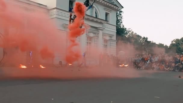 De man komt binnen met een rookbom in zijn handen. Zomer springen show. — Stockvideo