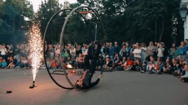 Ateş şovu aktörü, metal bir tekerleğin içinde yuvarlanarak tekerlekle numara yapıyor.. 