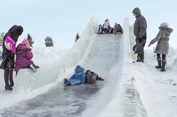 Kinderen op een ijs-hill Stockfoto